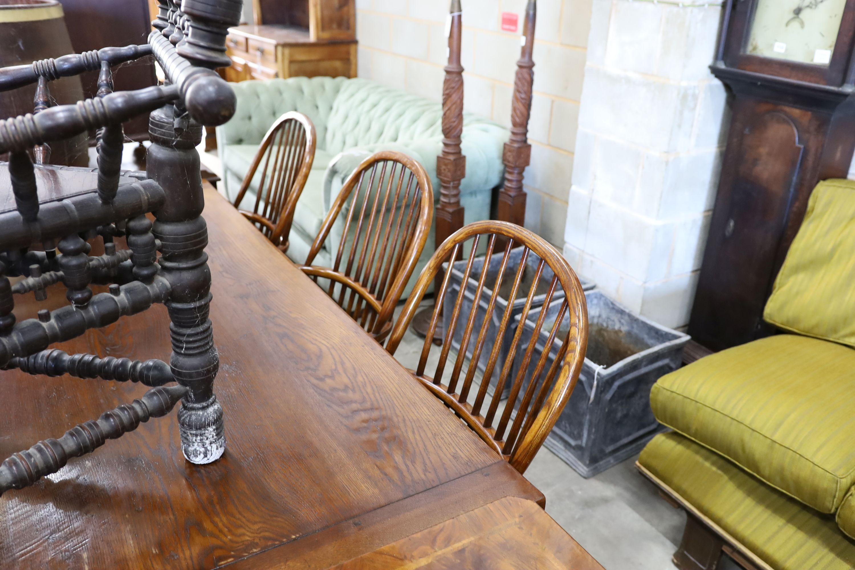 A set of six reproduction ash and elm Windsor comb back armchairs with saddle seats and crinoline stretchers, width 52cm, depth 45cm, height 102cm